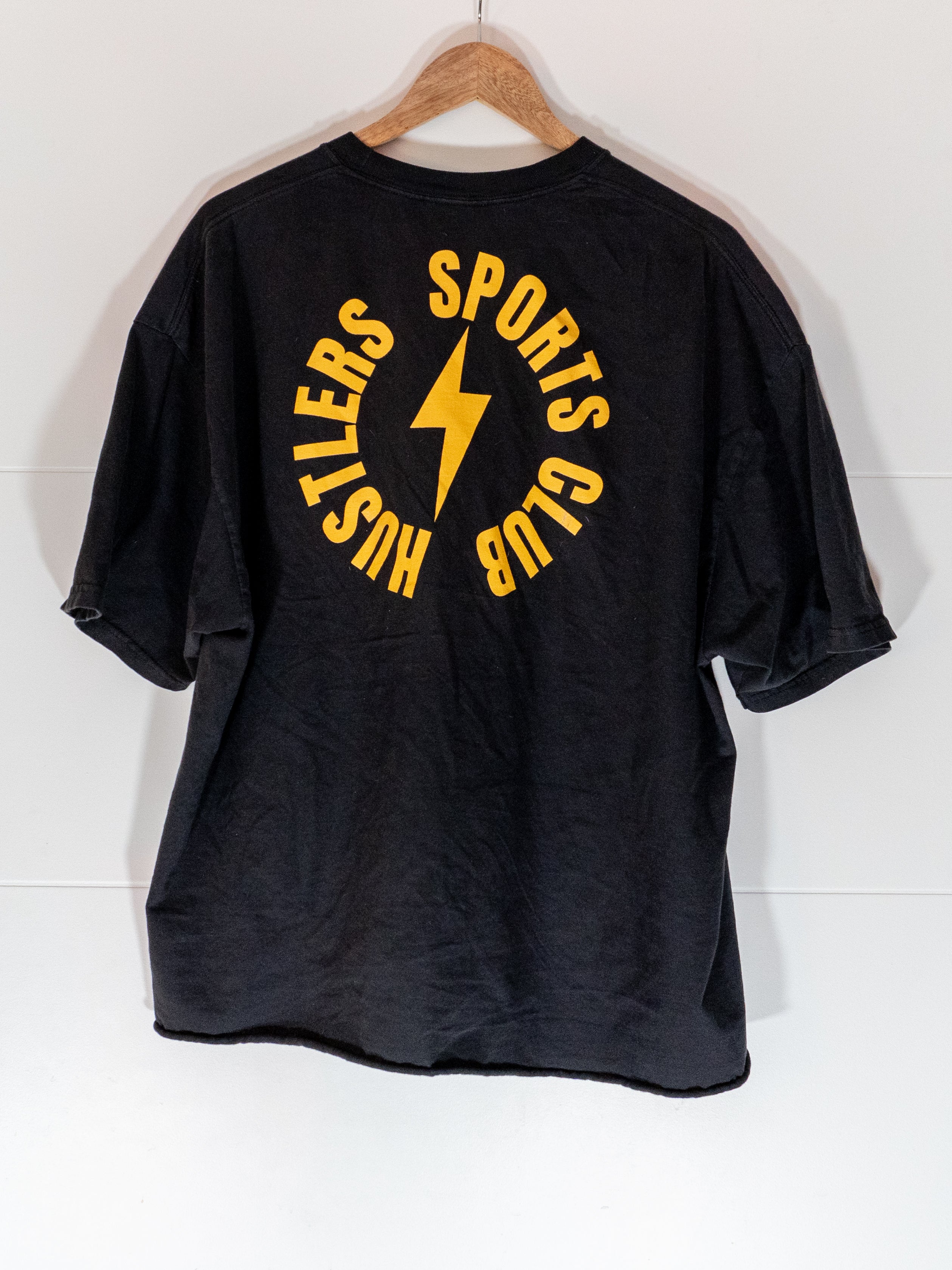 black hustlers sports club box tee with circular sports club seal on back