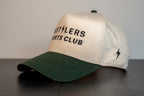 cream cap with forest green brim, hustlers sports club block wordmark and hsc signature on the side panel